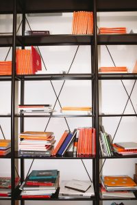 Explore a stylish bookcase filled with vibrant hardcover books in a modern indoor setting.