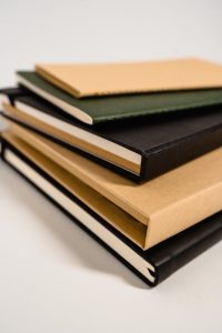 A neatly stacked collection of hardcover books showcasing their bindings.